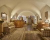 Eleganckie lobby z sklepionymi sufitami, drewnianymi elementami i wygodnymi fotelami.