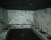 Pomieszczenie z marmurowymi ścianami i ławką.