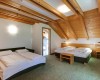 Pokój dwuosobowy z drewnianymi sufitami i dwoma podwójnymi łóżkami.