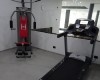 Sprzęt do ćwiczeń siłowych i bieżnia w siłowni z lustrem.