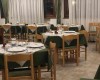 Restauracja z białymi i zielonymi obrusami na stołach przygotowana na kolację.