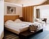 Elegancki pokój hotelowy z podwójnym łóżkiem, sofą i balkonem.