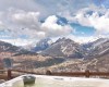 Zewnętrzne jacuzzi z widokiem na ośnieżone góry i dolinę.