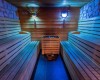 Drewniana sauna z oświetleniem i ławkami po obu stronach.