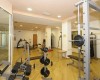 Siłownia z różnorodnym sprzętem do ćwiczeń, w tym hantlami i bieżniami.