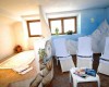 Pokój relaksacyjny z trzema leżakami, stolikiem z czasopismami i jacuzzi, ozdobiony malowidłem z motywem gór.