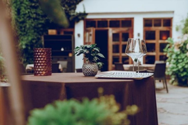 Stół w ogrodowej restauracji z dekoracjami i kieliszkami do wina.
