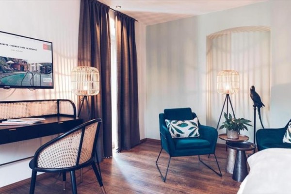 Nowoczesny salon z fotelami, lampami i telewizorem na ścianie.