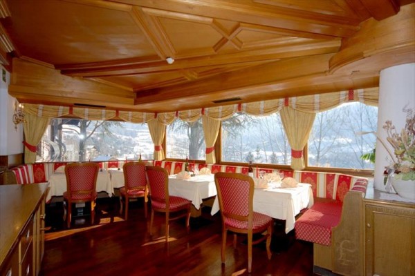 Restauracja z drewnianym wnętrzem i widokiem z dużych okien.