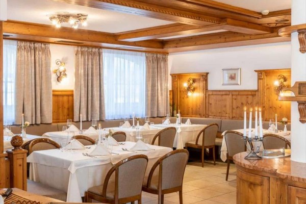 Restauracja z drewnianymi panelami i nakrytymi stołami.