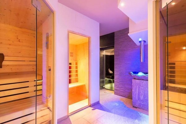 Sauna i pokój wellness z nowoczesnym oświetleniem i drewnianym wnętrzem.