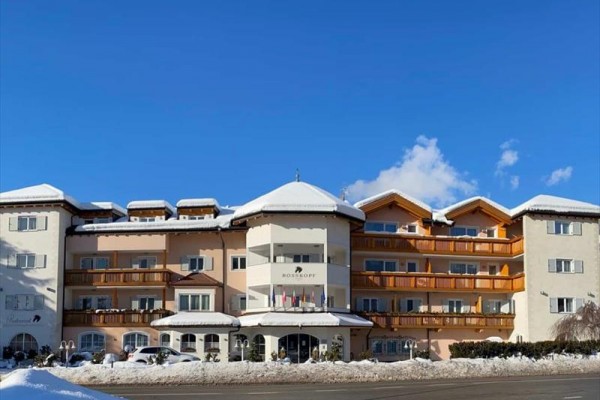 Widok z przodu na ośnieżony hotel pod niebieskim niebem.