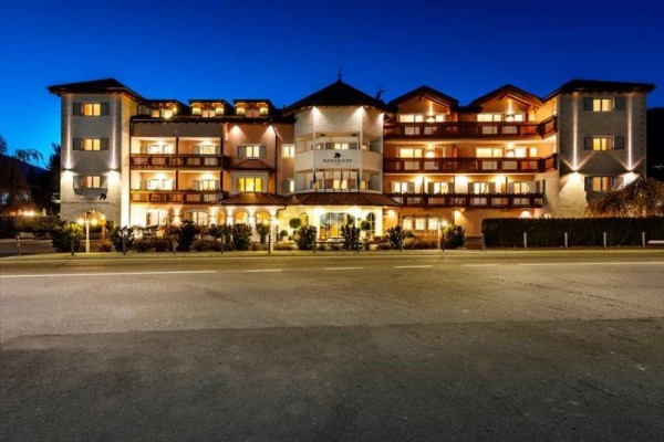 Jasno oświetlony budynek hotelu nocą.