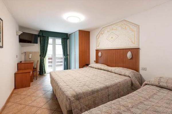 Pokój hotelowy z dwoma łóżkami i balkonem.