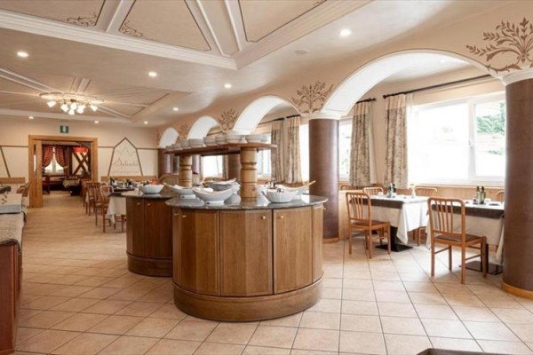 Elegancka restauracja z drewnianymi stołami i bufetem pośrodku pomieszczenia.  