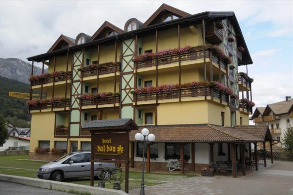 Hotel z drewnianymi balkonami pełnymi kwiatów.