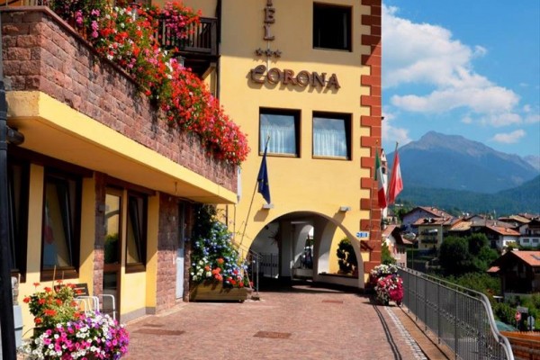 Budynek hotelu z kwiatami na balkonach w górskiej okolicy.