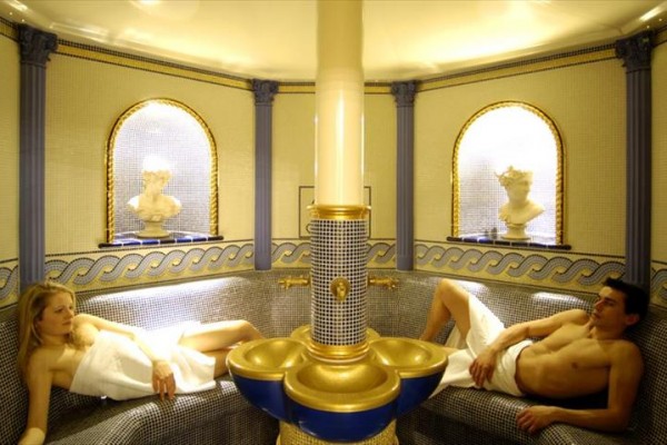 Pokój hotelowy z podwójnym łóżkiem, czerwonym dywanem i drewnianymi meblami.
