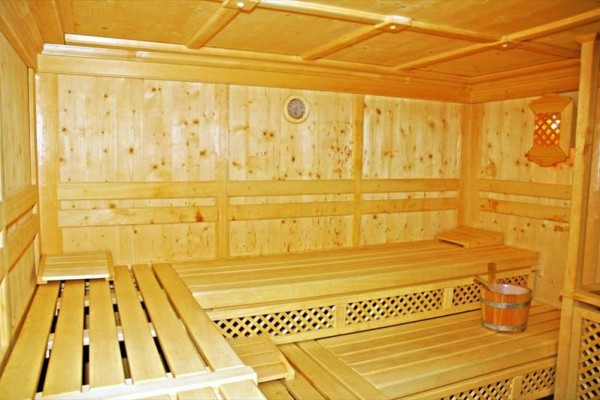 Sala zabaw dla dzieci z ścianką wspinaczkową, stolikami i kolorowymi zabawkami.