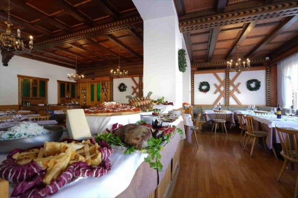 Stylowa restauracja z drewnianym sufitem i dużym bufetem pełnym jedzenia.