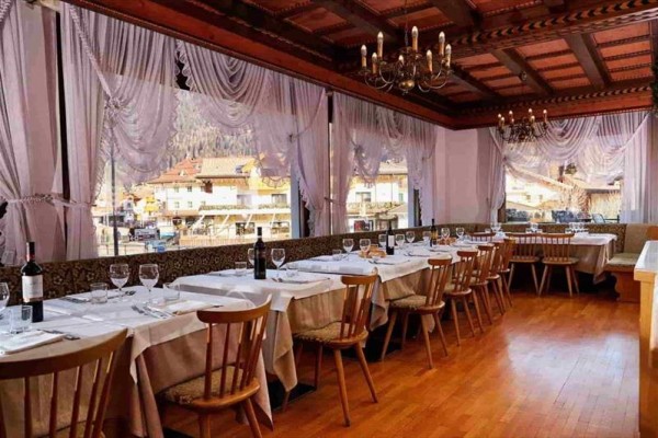 Restauracja z nakrytymi stołami i widokiem z okien na miasto.