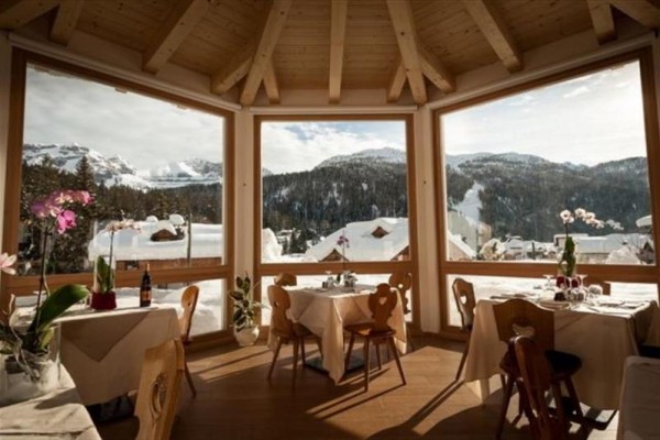 Restauracja z widokiem na ośnieżone góry i lasy.