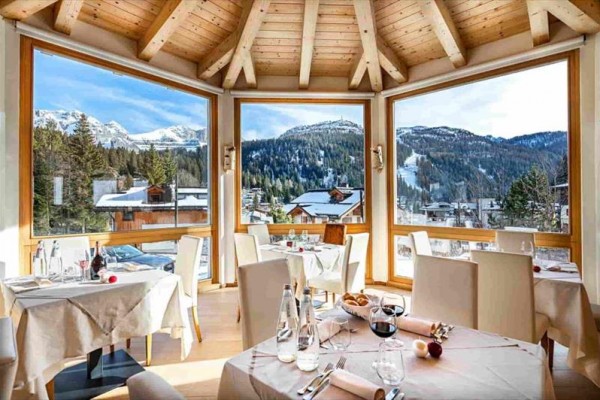 Restauracja z dużymi oknami oferująca widok na ośnieżone góry.