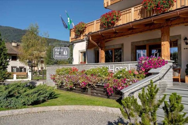 Wejście do hotelu Baita dei Pini z kwiatami na tarasie.