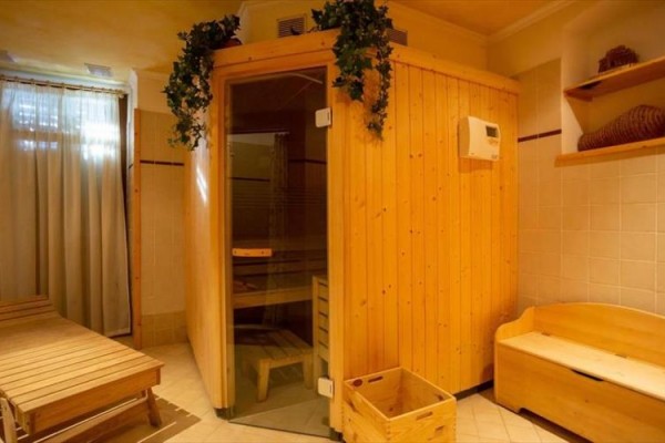 Drewniana sauna w przytulnym pomieszczeniu z leżanką.
