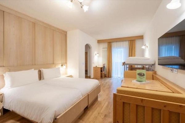 Nowoczesny pokój hotelowy z łóżkiem małżeńskim, piętrowym łóżkiem i biurkiem.