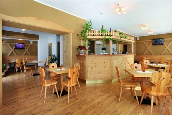 Restauracja z drewnianymi meblami i barem.