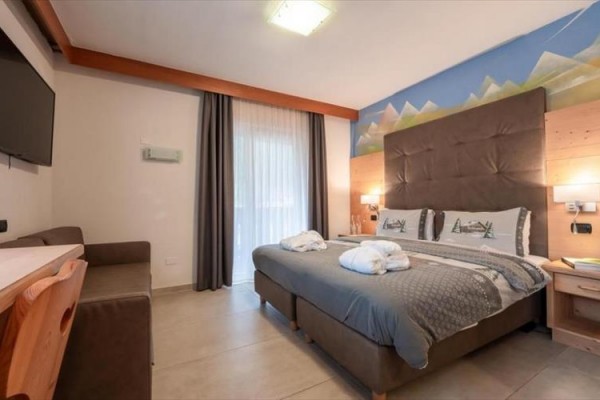 Komfortowy pokój hotelowy z podwójnym łóżkiem i nowoczesnymi meblami.