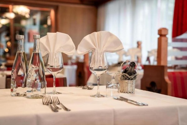 Elegancko nakryty stół w restauracji z butelkami wody i kieliszkami do wina.