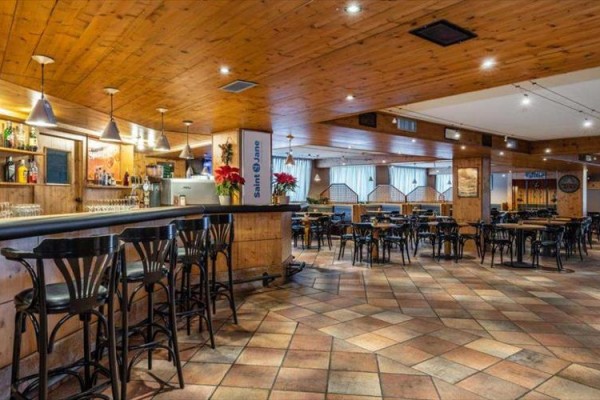 Wnętrze pustej restauracji z drewnianymi sufitami i podłogami.