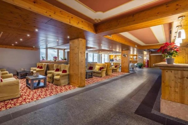 Hotelowe lobby z drewnianymi elementami i wygodnymi fotelami.  
