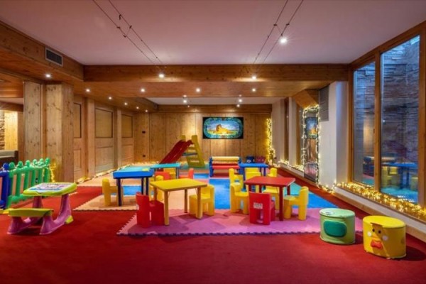 Sala zabaw dla dzieci z kolorowymi meblami i zabawkami.