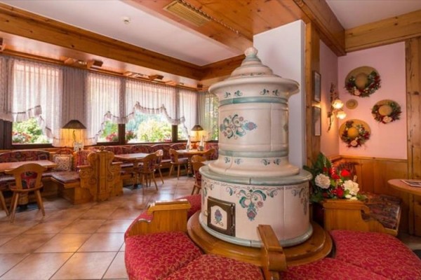 Stylowa restauracja z drewnianym wnętrzem i tradycyjnym ceramicznym piecem kaflowym.