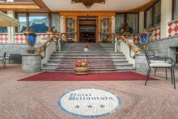 Wejście do hotelu z czerwonym dywanem i ozdobnymi schodami.