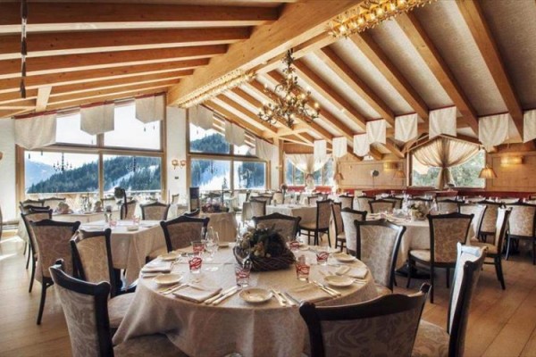 Restauracja z drewnianym sufitem i nakrytymi stołami.