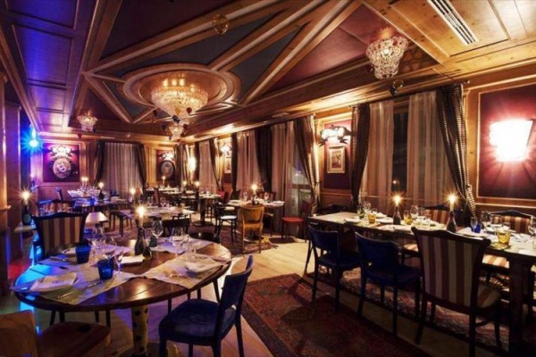 Luksusowa restauracja z eleganckim drewnianym wnętrzem i stonowanym oświetleniem.