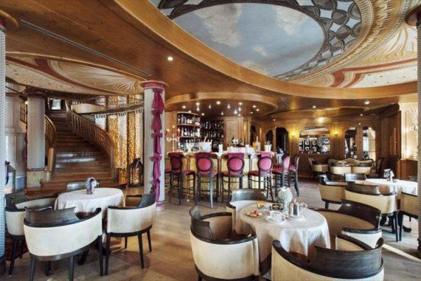 Luksusowa restauracja z okrągłym barem i malowanym sufitem.