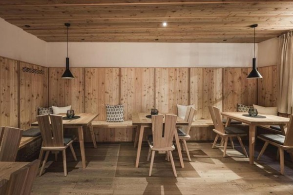 Drewniana restauracja z prostymi meblami i oświetleniem.