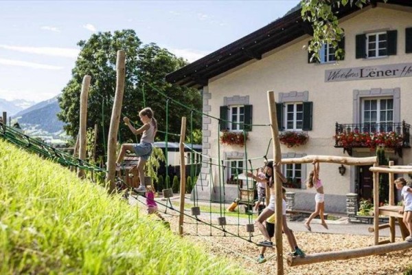 Dzieci bawią się na zewnętrznym placu zabaw obok budynku.