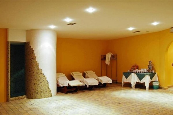 Pokój spa z leżakami i przekąskami na stole.