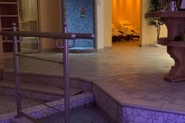 Strefa relaksu z leżakami i mozaikową ścianą w centrum wellness.