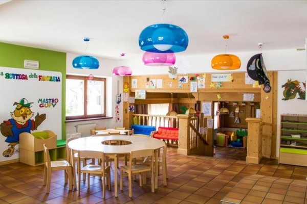 Kolorowa sala przedszkolna z meblami i zabawkami dla dzieci.