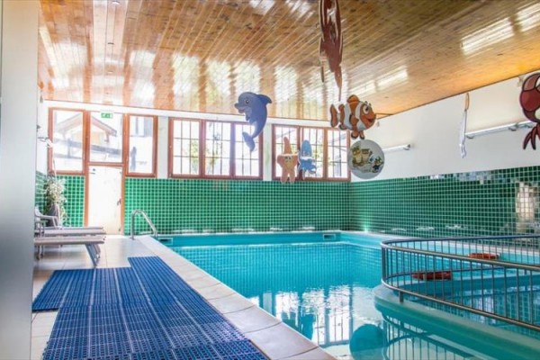 Kryty basen z kolorowymi mozaikami i dekoracjami morskich stworzeń.