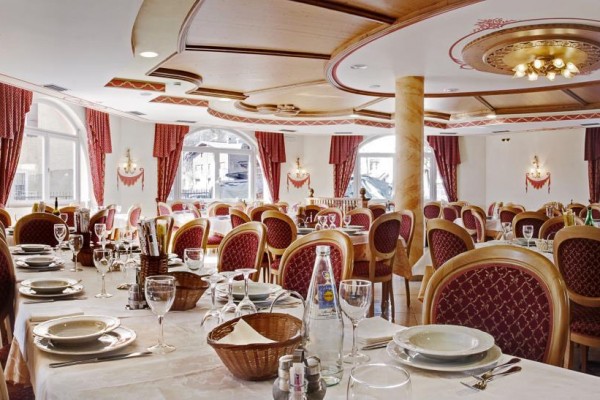 Restauracja z elegancko nakrytymi stołami i bogatym wystrojem.