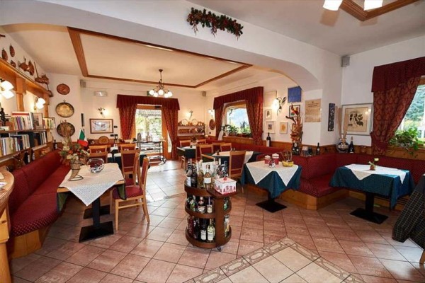 Wnętrze restauracji z drewnianymi meblami, zasłonami i dekoracjami.