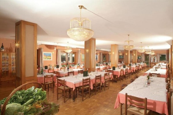 Restauracja z różowymi obrusami i żyrandolami na suficie.